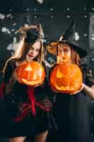 Free photo two girls in halloween costumes