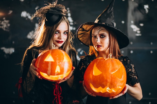 Free photo two girls in halloween costumes