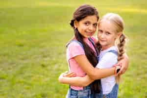 Free photo two girls hugging each other in a park