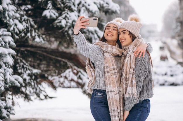 Two girls twins together in winter park