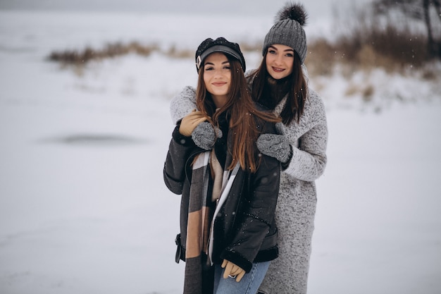 Two girls walking together in a winter park