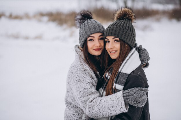 Two girls walking together in a winter park