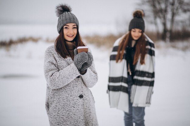 Two girls walking together in a winter park