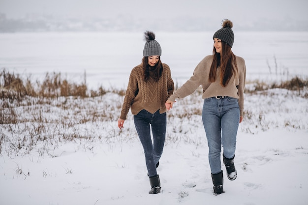 Two girls walking together in a winter park