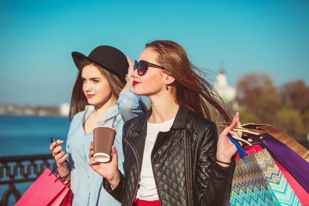 Two girls walking with shopping on city streets