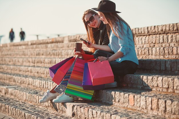 Two girls walking with shopping on city streets