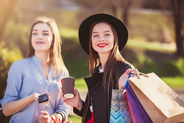 Two girls walking with shopping on city streets