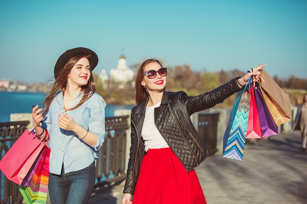 Two girls walking with shopping on city streets