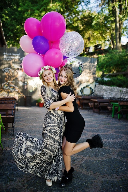 Free photo two girls wear on black with balloons at hen party