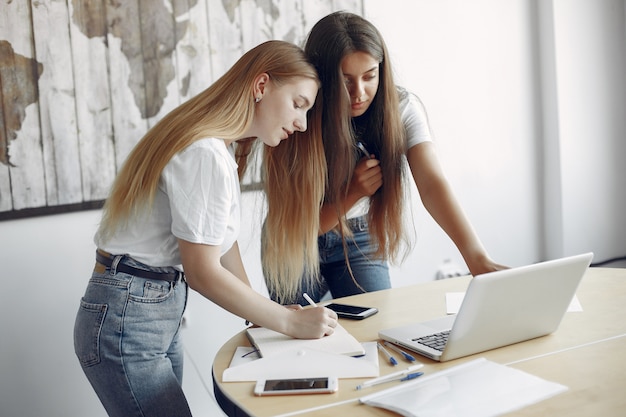 Free Photo two girls in a white t-shirts working at the office