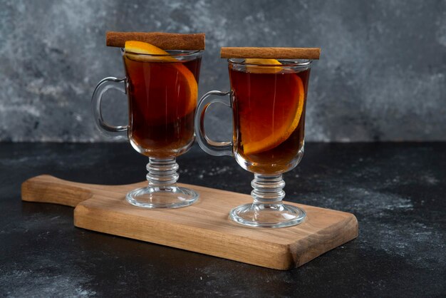 Two glass cups with fresh tea and cinnamon sticks.