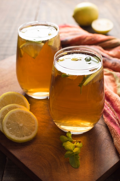 Two glass of lemon and ginger herbal tea on wooden table