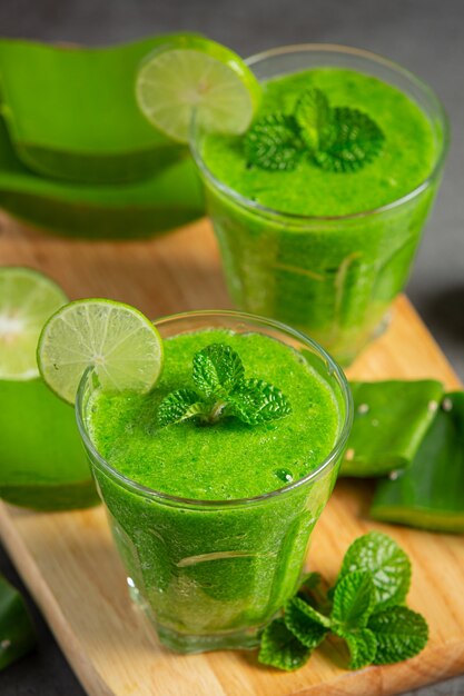 Two glasses of aloe vera  juice put on wooden cutting board