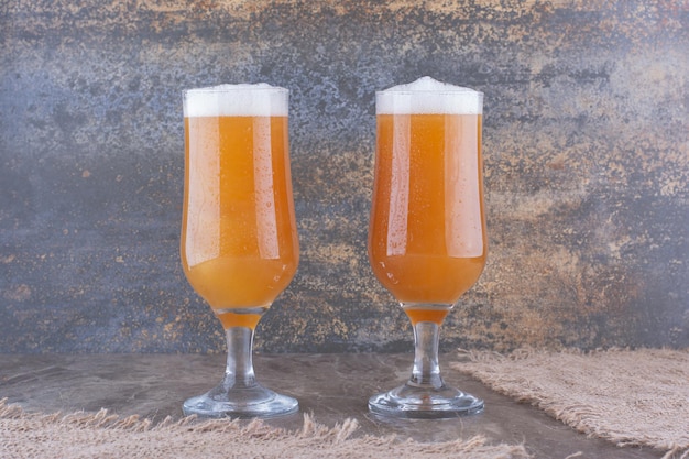 Two glasses of beer on marble table. High quality photo