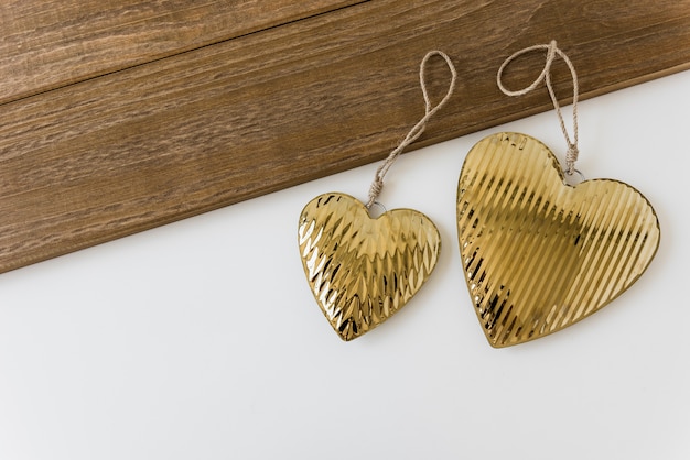 Two golden heart shape on white backdrop