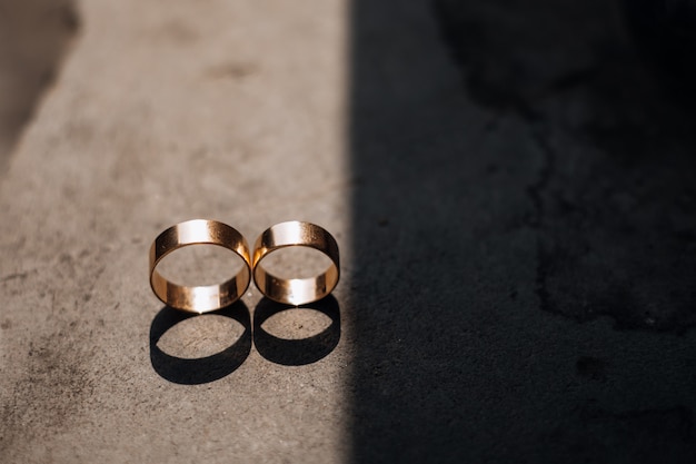 Free photo two golden wedding rings lie in the ray of light