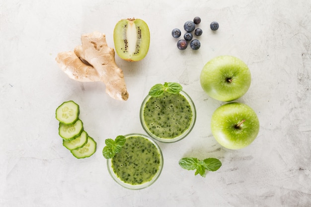 Two green smoothies with ingredients