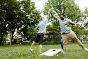 Free photo two guys giving each other a high five at a summer party