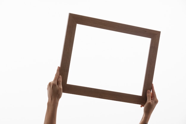 Free photo two hands holding wooden frame