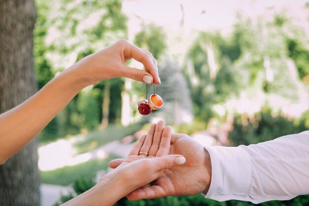 two hands of lovers and rings on a double cherry