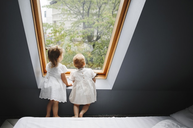 Two happy girls are looking at something in the window