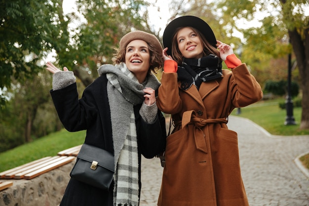 Free photo two happy girls dressed in autumn clothes walking