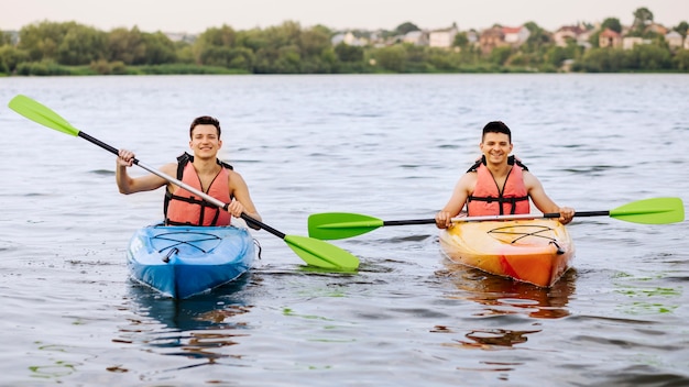 Free photo two happy man kayaking on lake