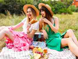 Free photo two happy sisters and best friends, enjoying picnic at vintage french style