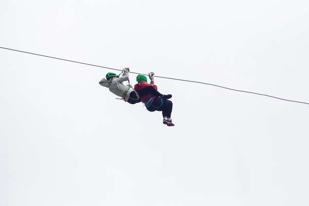 Two hiker on zip line adventure against sky at costa rica