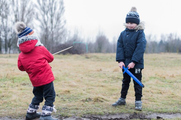 Two kids playing outside with mud