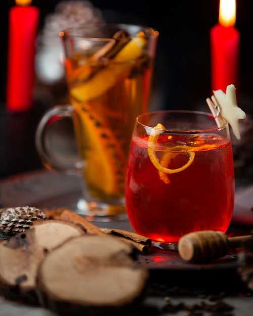 Two kind of red and yellow cocktails in red candle light.