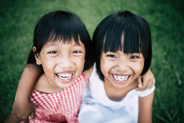 Two little girls friends playing funny in the park