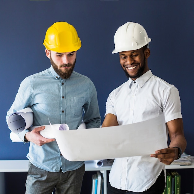 Two male engineers looking at blueprint