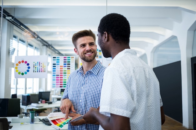 Two male graphic designers choosing color from the sampler