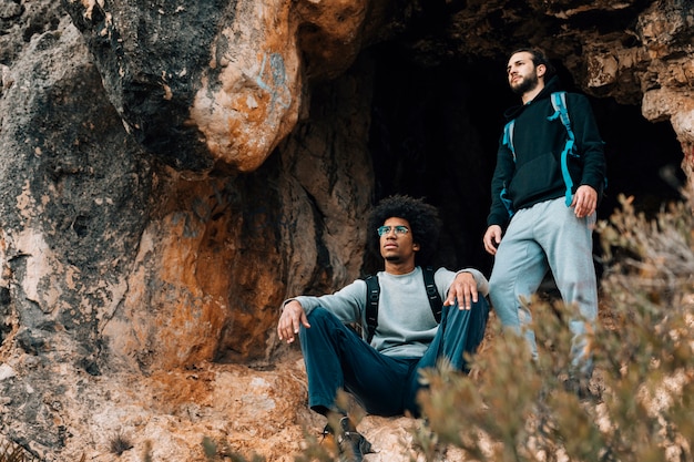 Free Photo two male hiker near the cave entrance