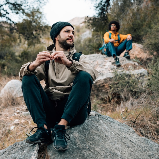 Free Photo two male hiker sitting on rock