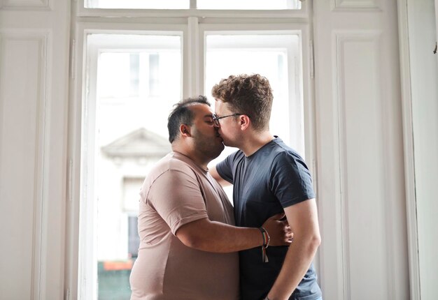 two men hug and kiss in the house