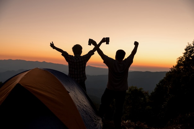 Two men tourists happy on the top of the mountain at near campfire 