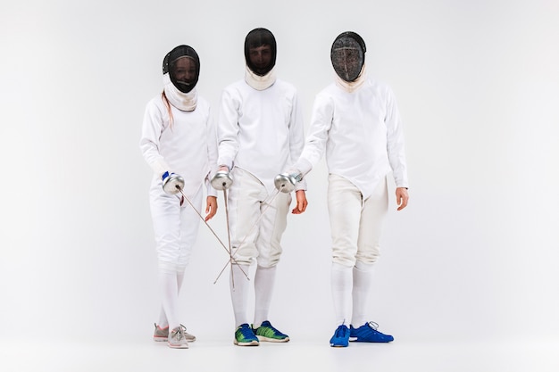 Free photo the two men and woman wearing fencing suit with sword against gray