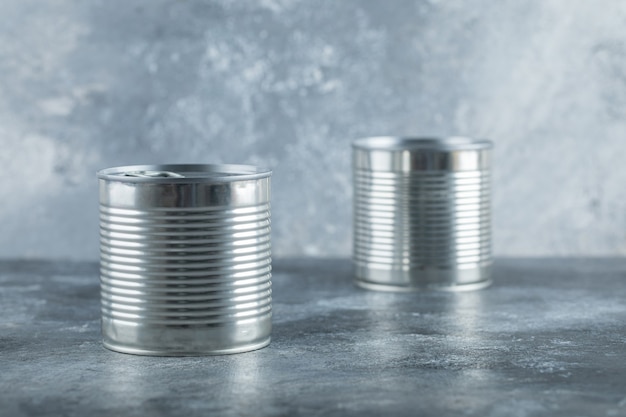 Two metallic cans on marble.