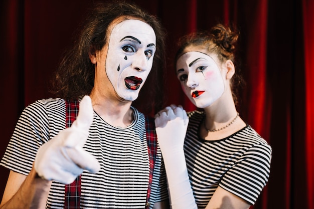 Free photo two mime artist with hand gesture