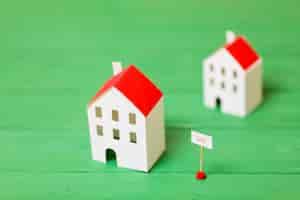 Free photo two miniature house models for sale on wooden green desk