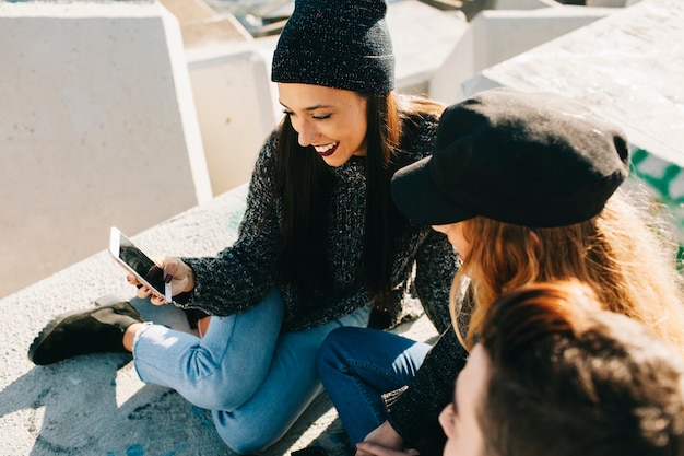 Two modern girls looking at smartphone