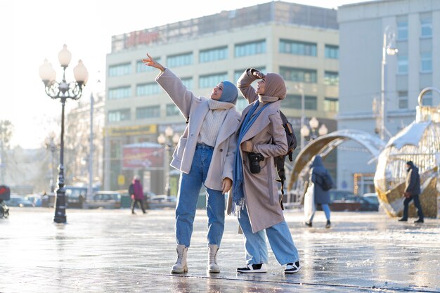 Two muslim female friends walking around the city while traveling