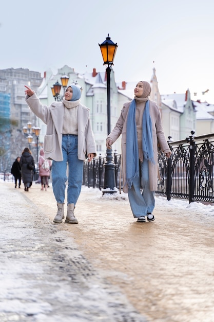 Free photo two muslim women with hijabs looking around while visiting the city