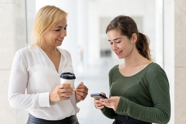 Free photo two office workers consulting on mobile internet