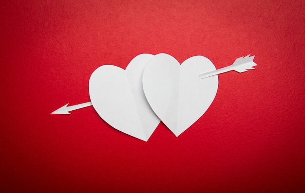 Two paper hearts pierced with an arrow symbol for Valentines day