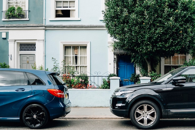 Two parked cars in front of an apartment entrance