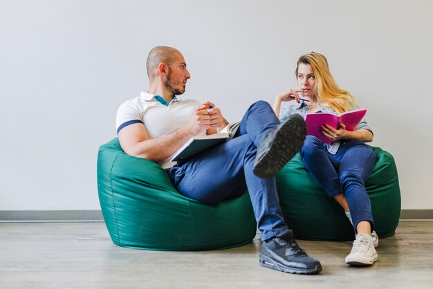 Two people reading notepads 