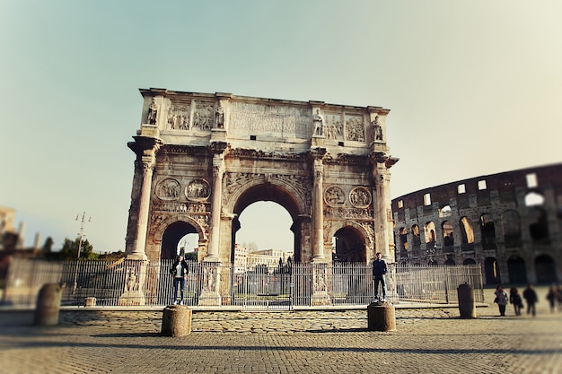 Free photo two people standing on the colums near arch of constantine